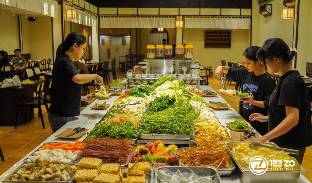 Quầy line buffet đầy ắp rau củ, nấm tươi và các loại đồ nhúng cho lẩu tại Lạc Buffet, trong không gian nhà hàng rộng rãi.