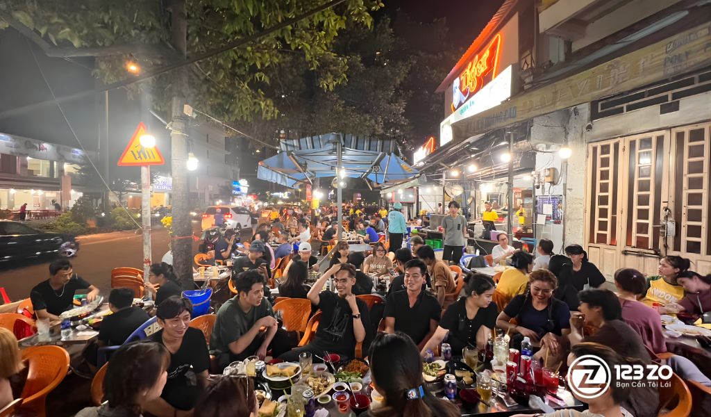 Quán ăn Tân Hồ Quận 7, bàn ghế nhựa đơn giản, khách ngồi đông đúc ngoài trời.