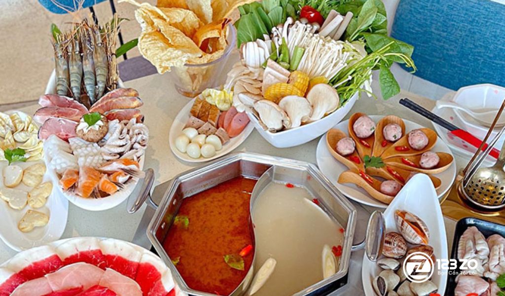 Nồi lẩu Đài Loan hai ngăn tại Yuhua với các món nhúng băng chuyền đa dạng như thịt bò cuộn, hải sản, nấm và rau củ tươi.