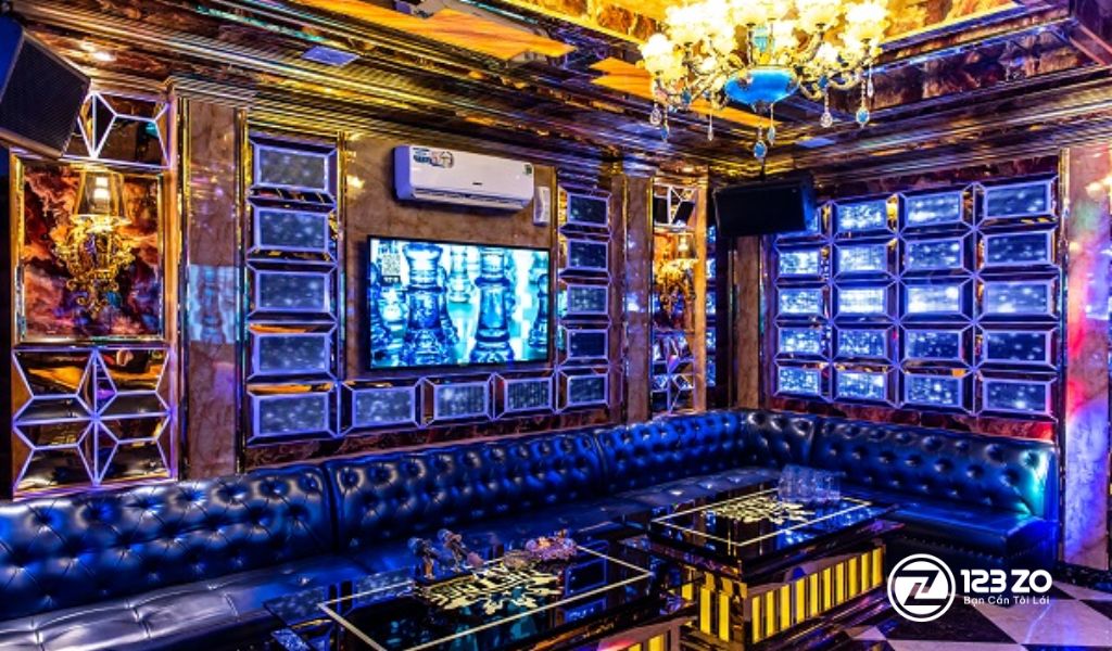 Phòng hát rộng lớn với thiết kế sang trọng, tông màu vàng ánh kim và ghế sofa dài tại quán karaoke nhà hàng The Tree Bình Thạnh.