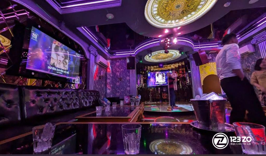 Top 13 Quán Karaoke Gò Vấp Giá Rẻ - Xuyên Đêm 2 Khách hàng đang hát và giải trí trong phòng karaoke được trang trí ánh sáng tím huyền ảo tại quán karaoke Nnice Gò Vấp.