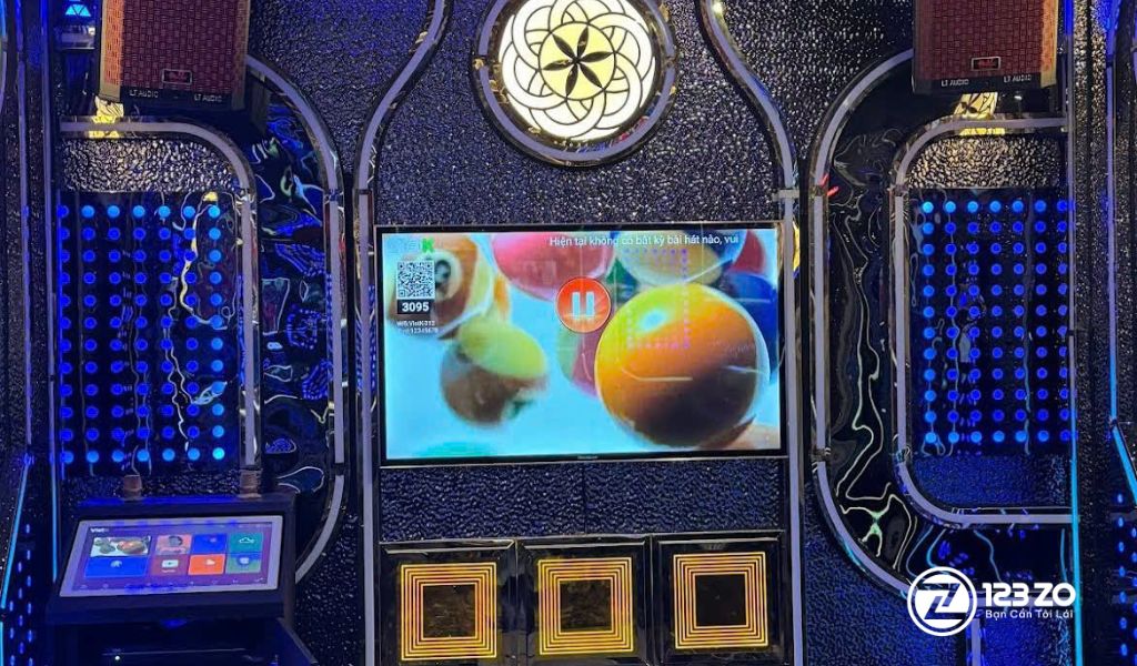 Top 13 Quán Karaoke Gò Vấp Giá Rẻ - Xuyên Đêm 13 Màn hình karaoke trung tâm với thiết kế tường ốp kim loại và đèn LED hình giọt nước tại quán karaoke Táo Đỏ Gò Vấp.