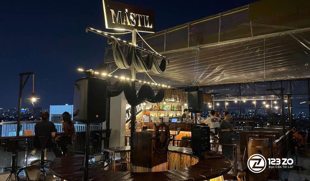 Quán rooftop tại Quận Phú nhuận trang trí theo chủ đề tàu thuyền (Mastil) vào buổi tối, có mái che và ánh đèn vàng lãng mạn.