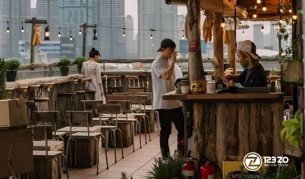 Quán rooftop tại Quận Phú Nhuận bằng gỗ mộc mạc tại Ráng Chiều Rooftop, phía sau là khung cảnh các tòa nhà cao tầng của thành phố.