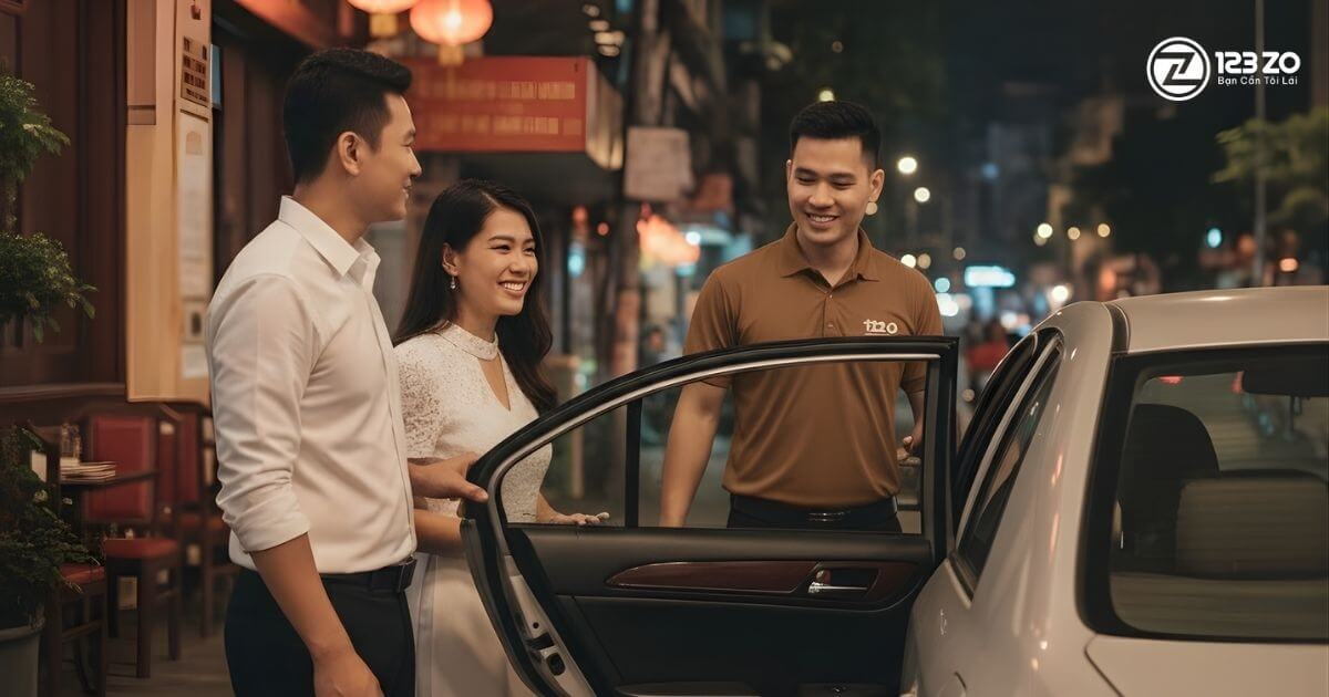 Tài xế 123ZO chuyên nghiệp, mặc đồng phục, niềm nở mở cửa xe đón khách hàng là một cặp đôi.