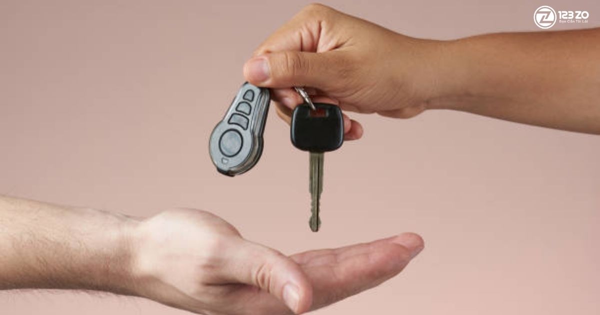 Tay người nhận chìa khóa ô tô từ tay người khác. Việc làm lái xe hộ Hóc Môn.