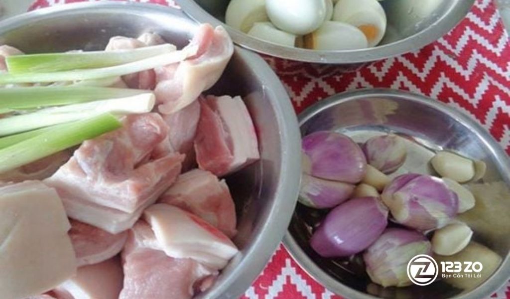 Sơ chế nguyên liệu: Thịt ba chỉ cắt miếng, hành tây, tỏi và trứng vịt luộc cho món Thịt Kho Tàu ngày Tết.