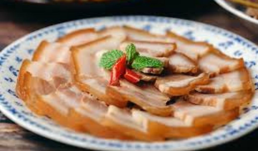 Đĩa Thịt Bỏ Mắm thành phẩm đã được thái lát mỏng, trang trí ớt và rau thơm.