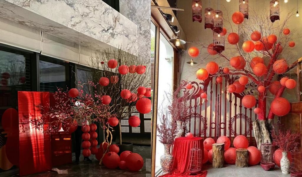 TOP 12 CÁCH TRANG TRÍ GÓC CHỤP ẢNH TẾT 2026 ĐẸP, THU HÚT TÀI LỘC 11 Trang trí góc chụp ảnh Tết với đèn lồng đỏ, treo trên cành cây lớn, tạo không gian lung linh, ấm áp và mang đậm nét truyền thống.