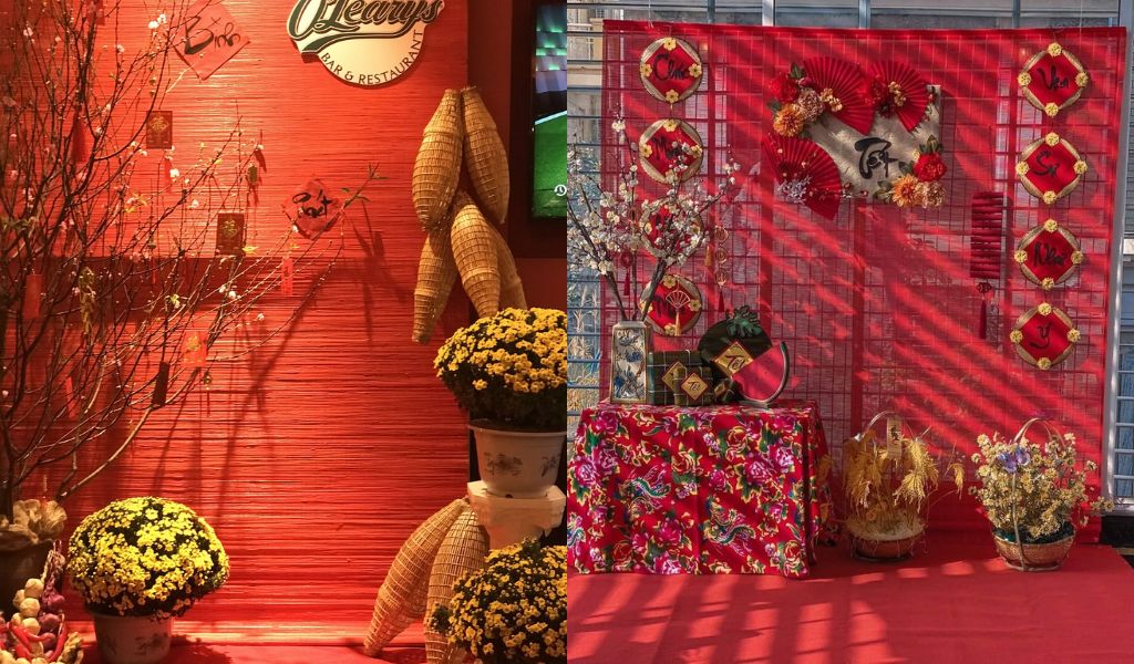 TOP 12 CÁCH TRANG TRÍ GÓC CHỤP ẢNH TẾT 2026 ĐẸP, THU HÚT TÀI LỘC 10 Trang trí góc chụp ảnh Tết phong cách tối giản nhưng ấm áp với phông nền tre nứa màu đỏ, điểm xuyết bằng hoa, cành đào và đồ trang trí tinh gọn.